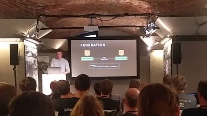 The photo contains a slide with the differenciation between short- and long term storage of metrics with Prometheus federation. In their case short term ~30 min and long term 32 days.